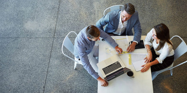 twee mannen en een vrouw bekijken de trends