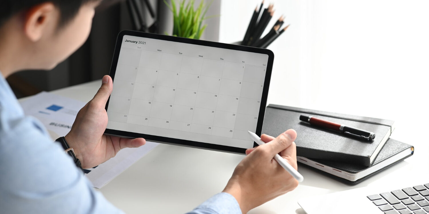 businessman-is-looking-calendar-with-daily-agenda-tablet Online planning maken invullen op tablet symagic